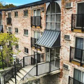 a brick building with a black railing